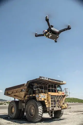 Drone hovering above a large mining haul truck on site